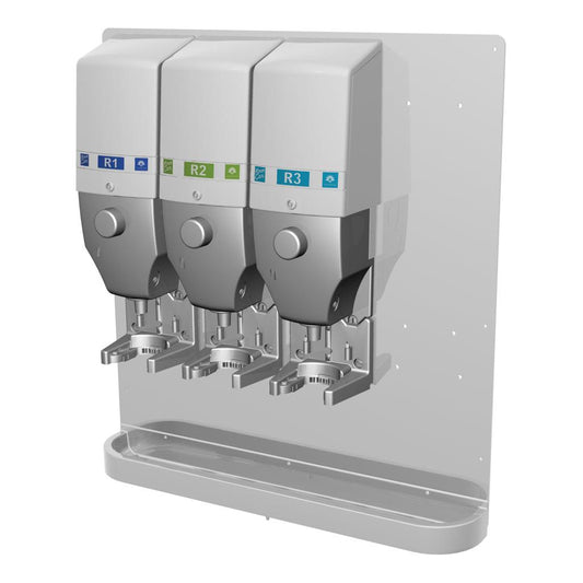 Drei DQFM-System-Spender (blau, grün, blau), wandmontiert mit einer Metall-Tropfschale, vorinstalliert für geringen Durchfluss. Kompatibel mit Hochkonzentrat für den hygienischen Gebrauch. Marke: Diversey Deutschland GmbH & Co. OHG.