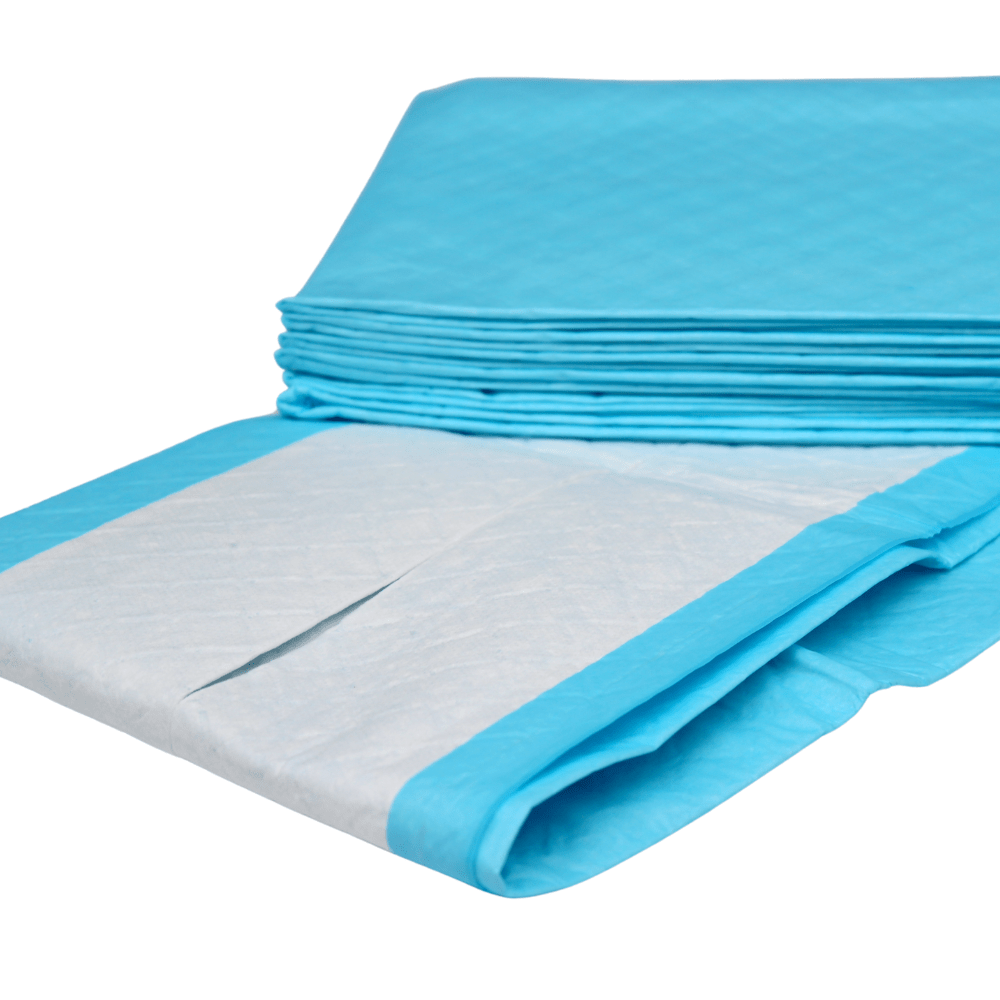 La photo représente une pile de altruan Altruflock® bleues, alèses de protection pour lit 60 x 90 cm, « Supersoft » et « Extrêmement absorbantes » | Paquet (25 pièces) de la marque Altruan, à usage unique. L'une des alèses est partiellement dépliée, de sorte que l'on peut voir la surface absorbante blanche bordée de bleu. Les alèses pour incontinence semblent être empilées les unes sur les autres de manière ordonnée.