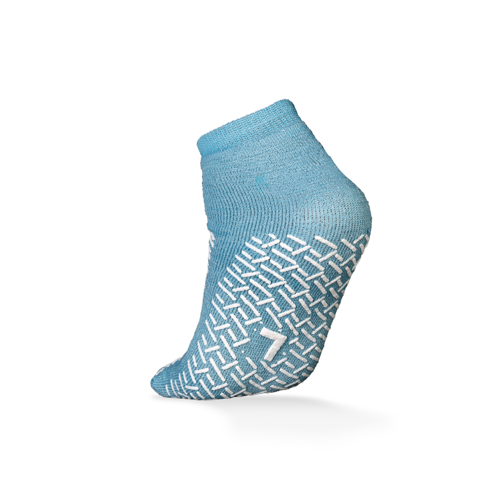 Abgebildet ist eine einzelne ECO-PLUS Anti-Rutsch Einwegsocke der AMPri Handelsgesellschaft mbH in hellblau mit weißem Antirutsch-Muster und der Zahl "7" auf der Sohle, ideal für den medizinischen Einsatz, vor einem schlichten weißen Hintergrund.