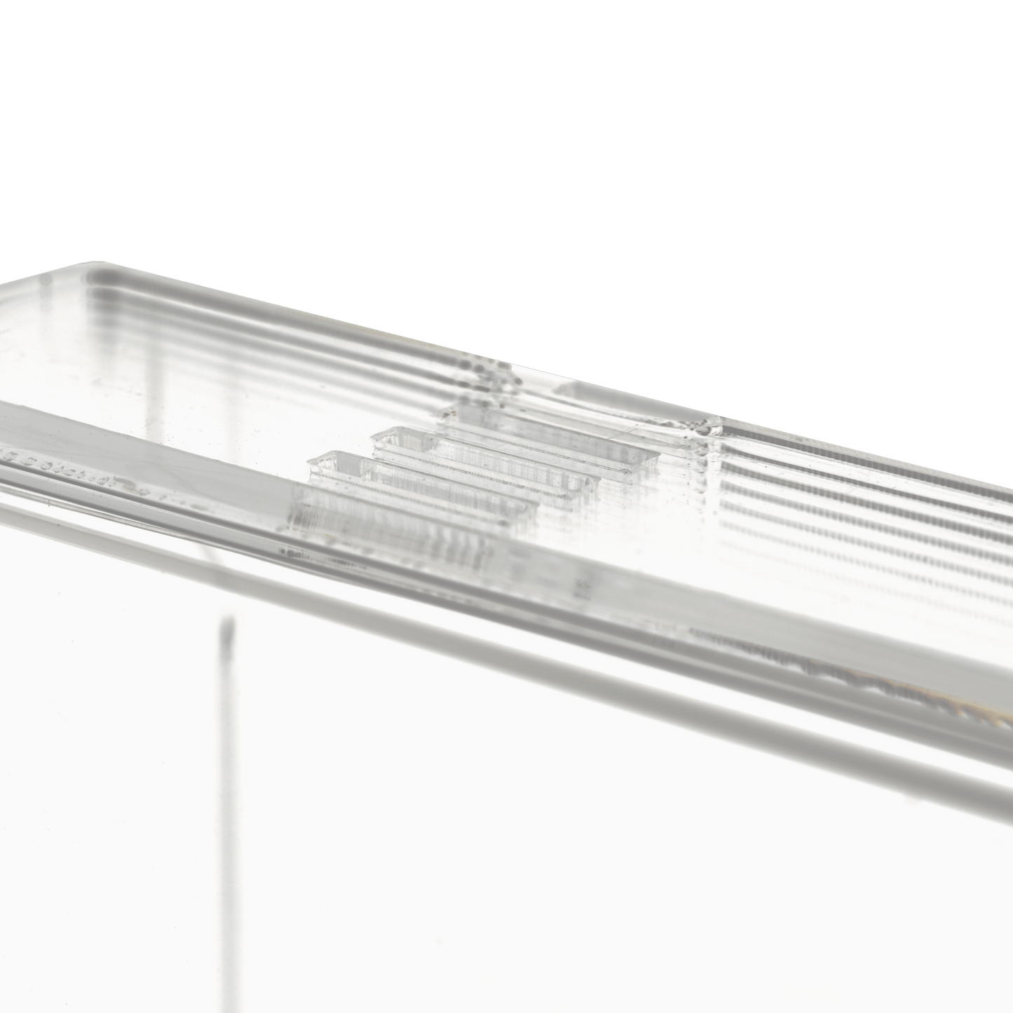 Close-up van de transparante, melkachtige wegwerphandschoenhouder (250 x 135 x 55-90 mm) van AMPri Handelsgesellschaft mbH, een rechthoekige acrylhouder met geribbelde randen op een effen witte achtergrond.