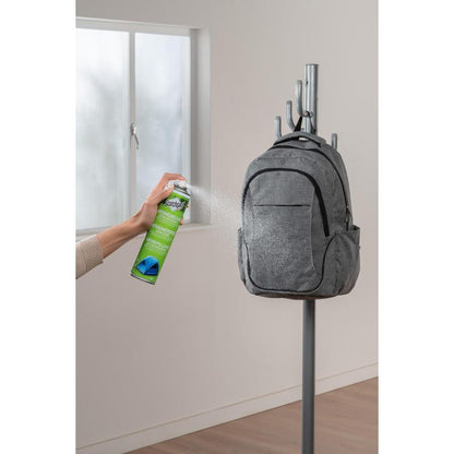 Une main vaporise du Scotchgard™ Imperméabilisant extra fort, 400 ml de 3M Deutschland GmbH, sur un sac à dos gris sur le portemanteau, pour offrir une protection imperméabilisante forte aux textiles.