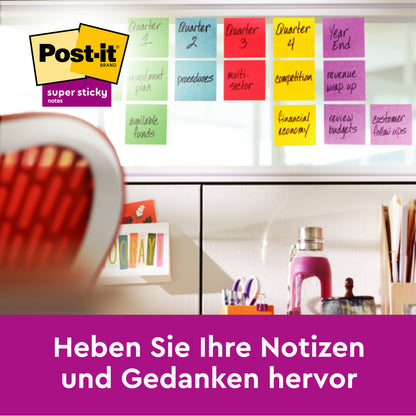 Eine Reihe bunter 3M Deutschland GmbH Post-it® Super Sticky Notes (76 mm x 76 mm, 90 Blatt/Block, 100% PEFC) mit handgeschriebenen Etiketten ist an einer Glaswand über einem Schreibtisch angeordnet. Unten deutscher Text: "Heben Sie Ihre Notizen und Gedanken hervor.