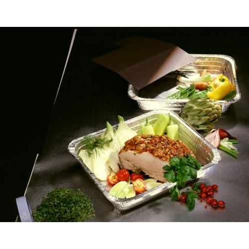 Trois conteneurs gastronormes Starpak 3 en aluminium (8,5 l, 8 cm x 32,6 cm x 52,7 cm) présentent des légumes tels que des tomates, du chou, des artichauts et des poivrons ainsi qu'un rôti assaisonné. Des herbes et du persil sont posés à côté des conteneurs sur la table sombre.