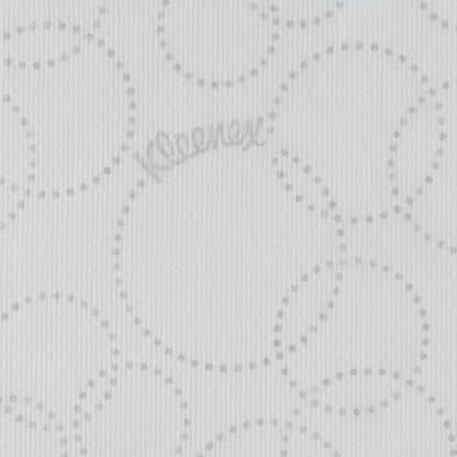 De close-up van een witte Kleenex® Ultra™ Handdoek MultiFold papieren doekje van Kimberly-Clark GmbH toont een lichtgrijs, gestippeld, cirkelvormig patroon, een subtiele "Kleenex"-branding tussen de stippen en een licht geribbelde textuur.