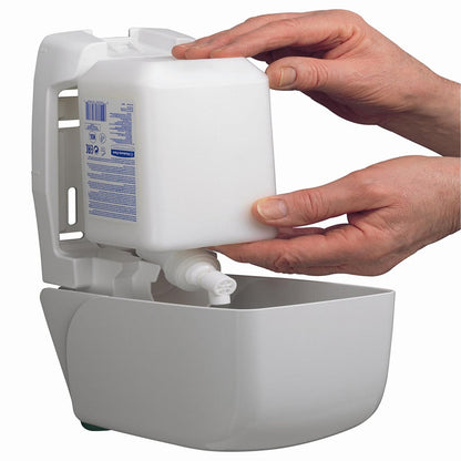 Deux mains insèrent une cartouche de lotion hydratante pour les mains et le corps Kleenex® de 1 litre de Kimberly-Clark GmbH dans un distributeur mural blanc, offrant ainsi un accès pratique à la lotion hydratante pour le soin des mains et du corps.