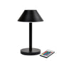 De LED-lamp Zelda Midi van Duni GmbH in modern grafietdesign met ronde voet en conische kap staat naast een afstandsbediening met kleurrijke knoppen - de ideale, energiezuinige verlichtingsoplossing.