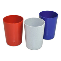 Trois verres à brosse à dents Nölle Profi Brush en plastique, de couleurs assorties (de la marque Nölle Profi Brush Bürsten- & Pinseltechnik e.K.), sont posés les uns à côté des autres dans la salle de bains : l'un est rouge, l'autre gris clair moucheté et le dernier bleu. Tous sont cylindriques et dépourvus de poignée.