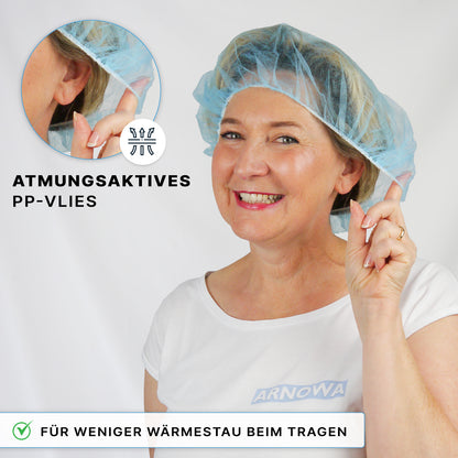Een vrouw glimlacht in een blauwe ARNOMED COVER PP-BARETTHAUBE van ARNOWA GmbH en wijst naar het ademende PP-vlies met de opschriften "ademend PP-vlies" en "hitteverminderd - ideaal voor de hygiënezone".