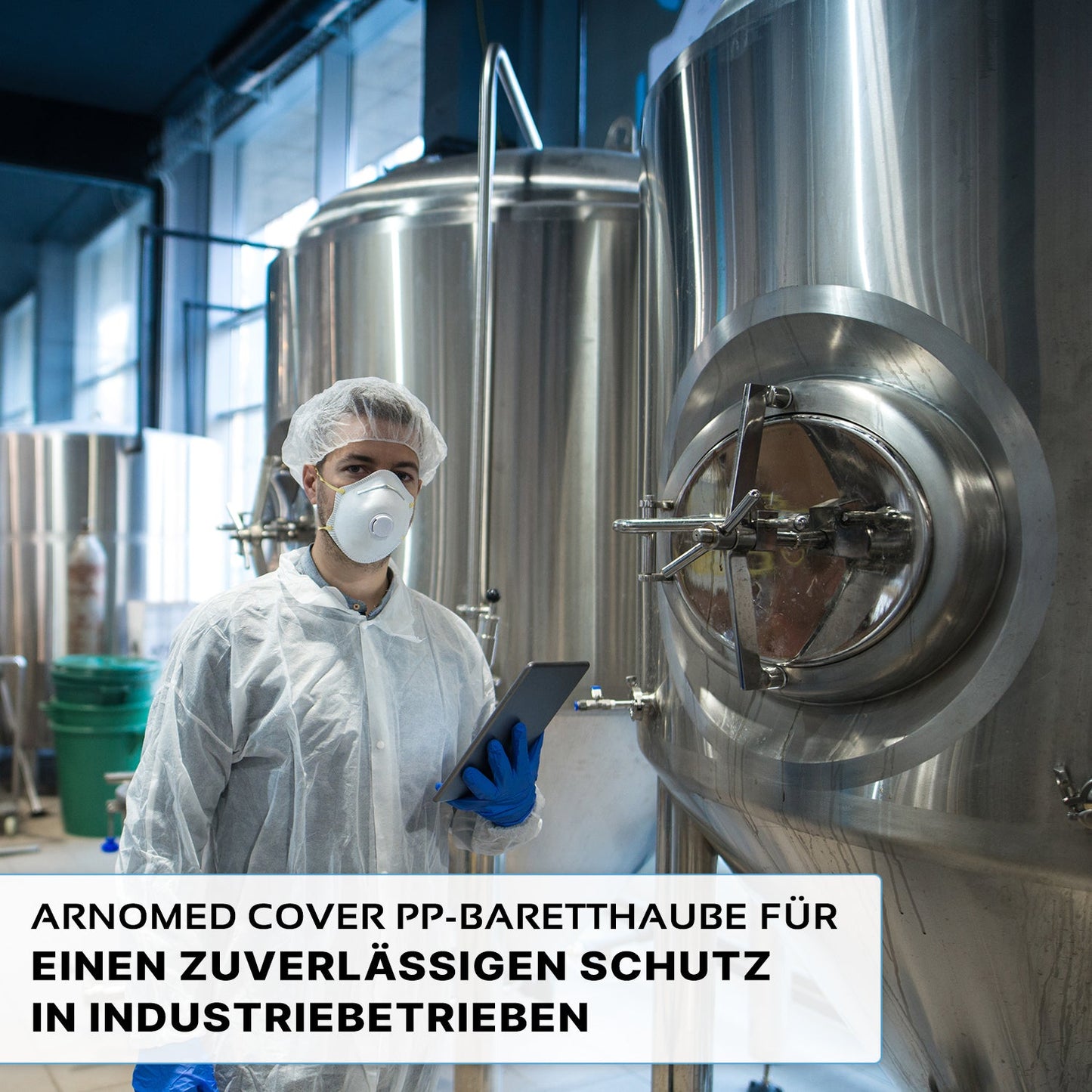 Een persoon in beschermende kleding, waaronder de ARNOMED COVER PP-BARETTHAUBE van ARNOWA GmbH en een masker, houdt een tablet naast roestvrijstalen tanks in een hygiënische industriële zone. De Duitse tekst over betrouwbare bescherming wordt onderaan weergegeven.