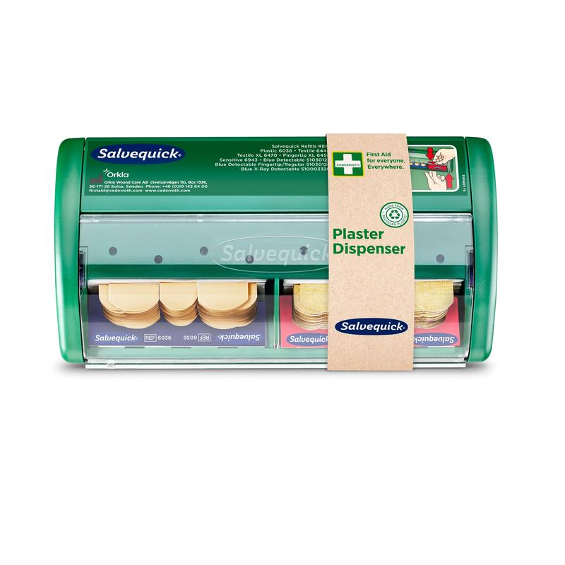 De Salvequick pleisterdispenser van Orkla Wound Care AB is een groene pleisterdispenser met transparante voorkant, met twee vakken voor pleisters en een bruin etiket aan de rechterkant met het opschrift "Pleisterdispenser". Verpakking (1 stuk).