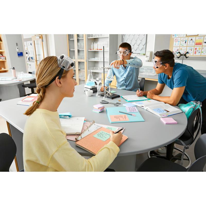 Drie studenten met veiligheidsbrillen werken samen aan een laboratoriumtafel. Terwijl de een de apparatuur instelt, maken de anderen notities met Post-it® Super Sticky Notes (47,6 mm x 47,6 mm, 90 vel/blok, 100% PEFC) van 3M Deutschland GmbH.