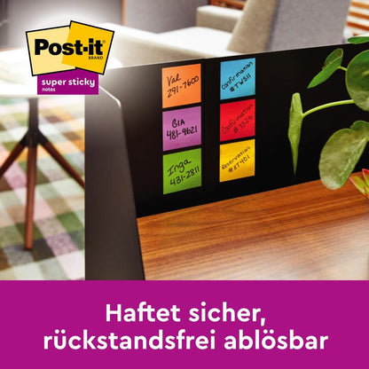 Op de zijbalk van een zwarte computermonitor zijn zes kleurrijke Post-it® Super Sticky Notes (76 mm x 76 mm, 90 vel/blok, 100% PEFC) van 3M Deutschland GmbH met handgeschreven notities naast een plant en een statief te zien. "Hecht veilig, residuvrij verwijderbaar."