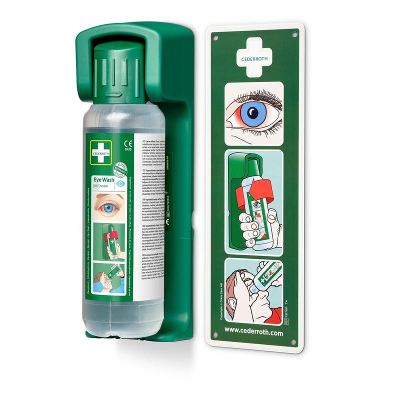 Afgebeeld is een wandgemonteerde Orkla Wound Care AB houder voor 500 ml oogspoeling met een nagloeiend waarschuwingsbord en een overzichtelijk instructiediagram voor stapsgewijze oogspoeling.