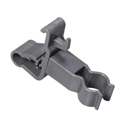 Der TASKI Zubehörhalter der Diversey Deutschland GmbH & Co. OHG ist eine graue Kunststoffklammer mit zwei runden Öffnungen und einem Verriegelungsscharnier. Er dient zur sicheren Befestigung zylindrischer Reinigungswerkzeuge und zur Organisation von Reinigungszubehör. Glatte Oberfläche, abgewinkelte Details.