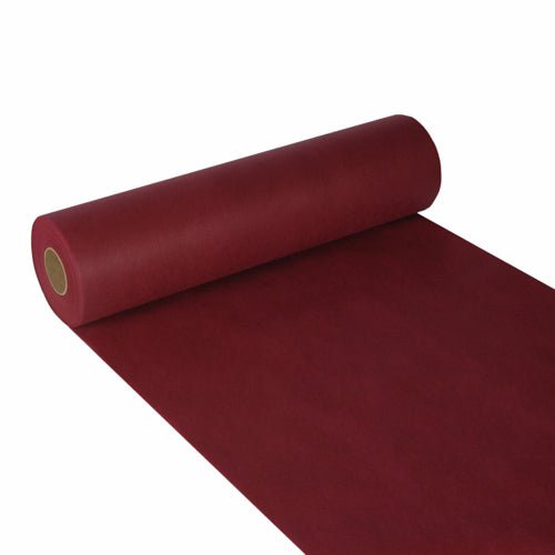 Een gedeeltelijk afgerolde Starpak tafelloper, stofachtig vlies „soft selection“ (24m x 40cm), in donkerrood, is afgebeeld op een witte ondergrond met een glad, mat oppervlak – ideaal voor stijlvolle decoratie. Het papier is om een kartonkern gewikkeld.