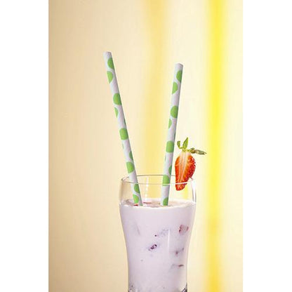 Un verre avec une boisson crémeuse et blanche et des morceaux de fruits est couronné de deux PAPSTAR 100 pailles, papier Ø 6 mm de PAPSTAR GmbH, avec des points verts et une tranche de fraise sur le bord, devant un fond jaune vif.
