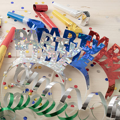 Les PAPSTAR 4 serre-têtes colorés assortis « Métallique » de la PAPSTAR GmbH brillent dans des couleurs métalliques vives comme le bleu, le rouge et l'argent – idéal pour les fêtes avec des confettis, des rubans ondulés et des bruiteurs colorés sur un fond de bois clair.