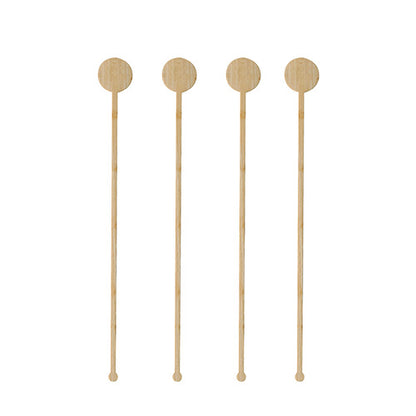 Vier PAPSTAR 100 drankroerders van bamboe 'pure' van het merk PAPSTAR GmbH met ronde, platte koppen zijn verticaal in een rij voor een witte achtergrond gerangschikt.