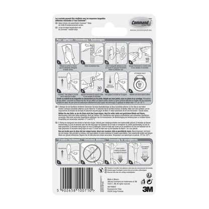 L'arrière d'un emballage de crochet pour serviettes de bain Command™ de 3M Deutschland GmbH contient des instructions illustrées et écrites étape par étape en plusieurs langues pour appliquer et retirer les bandes, ainsi qu'un code-barres et le logo 3M en bas.