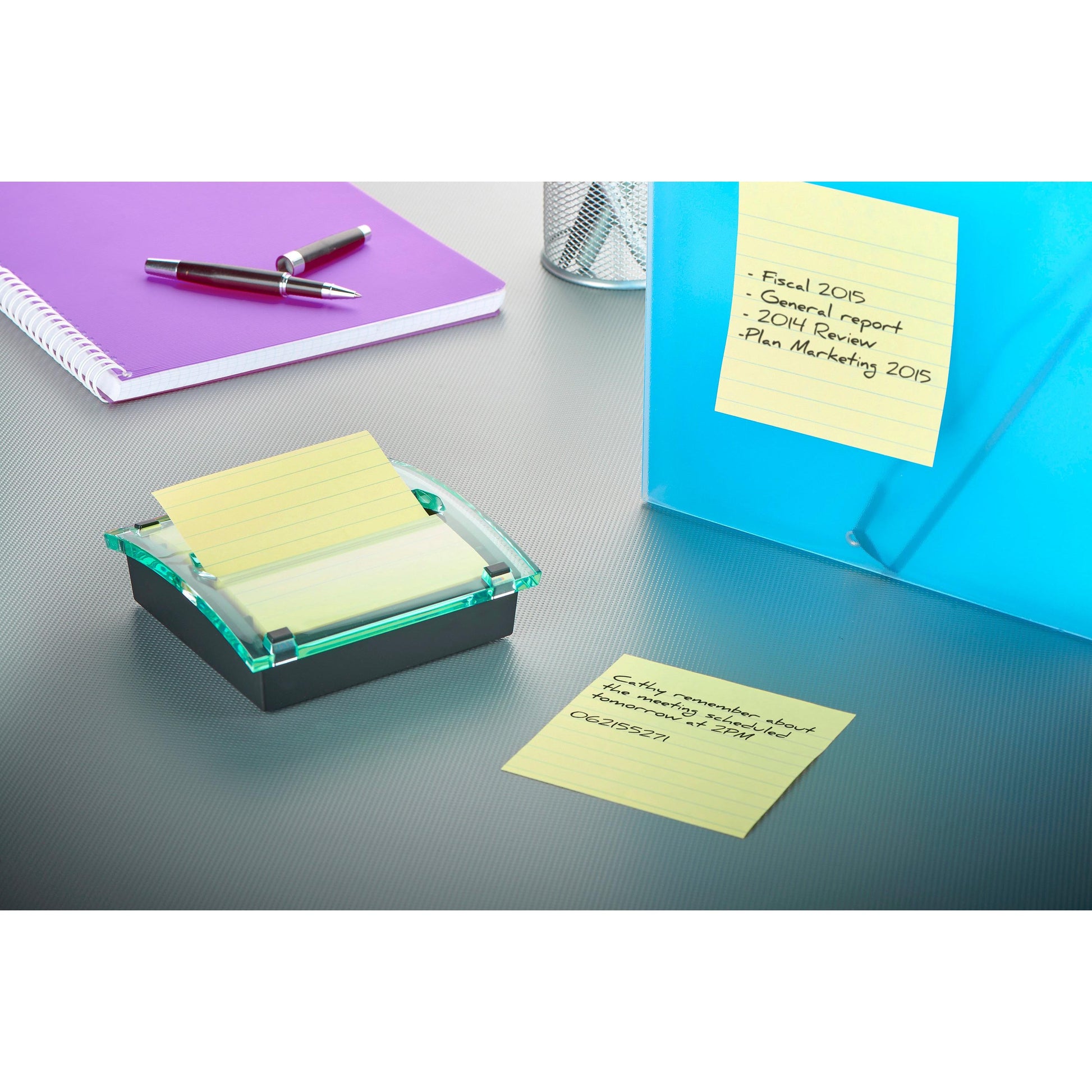 Auf einem grauen Schreibtisch liegen ein lila Notizbuch, ein silberner Stift, ein 3M Post-it® Z-Notes Dispenser XL (schwarz) mit Super Sticky Z-Notes (gelb, liniert, 101x101mm), handgeschriebene Haftnotizen, eine blaue Mappe und ein Metallnetz-Stifthalter.