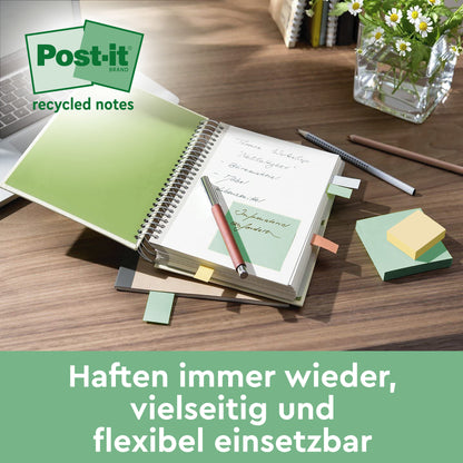 Auf einem Schreibtisch liegen ein Post-it® Recycling Notes Block (76x76 mm, 100 Blatt/Block, 100% PEFC) der 3M Deutschland GmbH, grüne und bunte Notizen, ein Kugelschreiber, ein Bleistift, eine Tastatur, ein aufgeschlagenes Notizbuch mit einer grünen Notiz und eine Vase mit Grünpflanzen. Abgebildeter deutscher Text.
