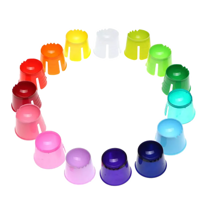 Er wordt een cirkelvormige opstelling getoond van kleurrijke AMPri PP wegwerp-dappenbekerkappen in de tinten rood, oranje, geel, wit, groen, blauw, paars en roze in een harmonisch kleurverloop, tegen een stralend witte achtergrond.