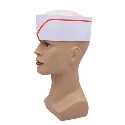Une tête de poupée présente la coiffe AMPri avec couronne en non-tissé réglable, disponible en différentes couleurs chez AMPri Handelsgesellschaft mbH. Ce bonnet en papier blanc avec bande rouge est souvent utilisé comme produit jetable dans l'industrie alimentaire. La vue de profil sur un fond uni souligne son design pratique.