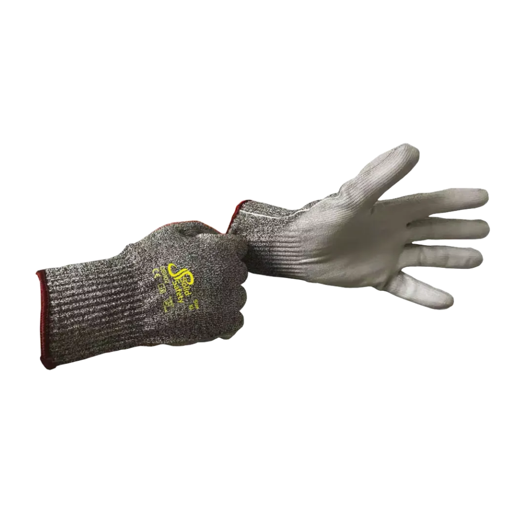 Une personne porte un gant de protection contre les coupures AMPri SolidSafety Cut High en matériaux résistants aux coupures à la main gauche, tandis que la main droite tient le poignet d'un deuxième gant. Ces gants gris de la société AMPri Handelsgesellschaft mbH sont fabriqués en fil HPPE avec un logo jaune au dos, une texture côtelée et un bord rouge à la manchette.
