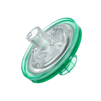 Un gros plan du filtre d'injection Sterifix® de B. Braun, fabriqué par B. Braun La société Deutschland GmbH & Co. KG présente un filtre en plastique vert, rond et transparent, fréquemment utilisé dans les applications cliniques. Il est doté d'un raccord cylindrique central et d'une base ronde. Sa conception comporte plusieurs couches visibles grâce à son matériau transparent, afin d'empêcher toute contamination bactérienne.