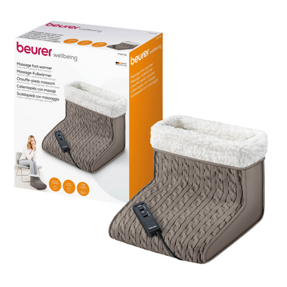Exposé est un Beurer FWM 45 chauffe-pieds de massage emballé de Beurer GmbH. La boîte blanche montre une image du produit et une femme qui l'utilise. Le chauffe-pieds est en tricot gris avec une doublure en peluche blanche et une unité de commande noire pour des niveaux de chaleur réglables. Le nom du produit « Beurer FWM 45 chauffe-pieds de massage | Emballage (1 pièce) » est imprimé en plusieurs langues.