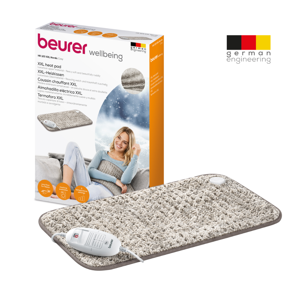 Image d'un Beurer coussin chauffant HK 123 XXL Nordic au format XXL avec emballage. Le coussin chauffant structuré gris dispose d'un régulateur blanc et offre 3 niveaux de chaleur pour un confort personnalisable. L'emballage montre une femme utilisant le coussin, met en avant les caractéristiques du produit dans plusieurs langues et affiche fièrement le logo de Beurer GmbH et « Ingénierie allemande ».