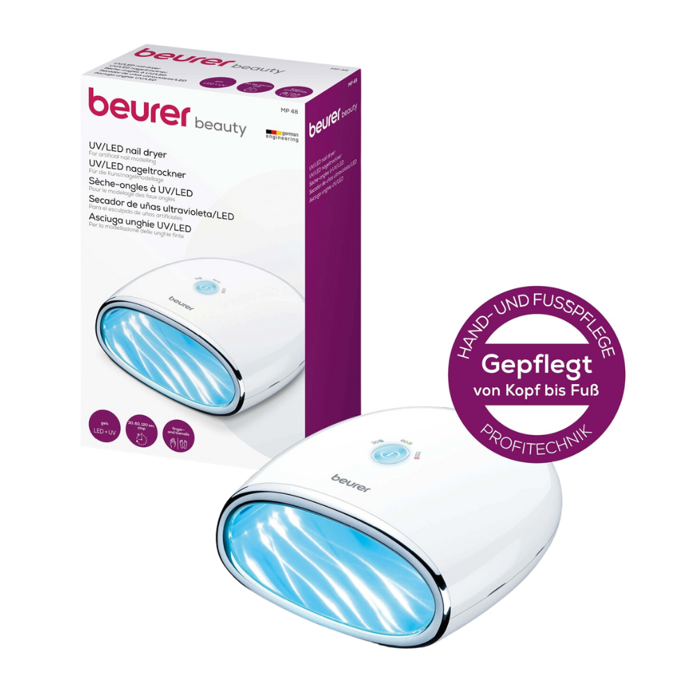 L'article discontinué Beurer MP 48 LED/UV-sécheur d'ongles de Beurer GmbH est placé à côté de son emballage. La lampe à ongles convient pour le soin des mains et des pieds ainsi que pour la modélisation des ongles artificiels. Sur la boîte, les détails et le branding sont affichés en allemand.
