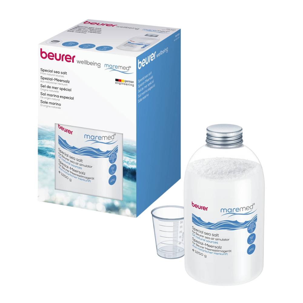 Een productafbeelding toont een doorzichtige plastic container, die gevuld is met Beurer maremed® MK speciaal zeezout inclusief maatbeker | Verpakking (1 stuk) en is gelabeld met „Beurer GmbH“. Daarnaast toont de verpakkingsdoos hetzelfde merk en beschrijving in meerdere talen. Naast de container bevindt zich ook een maatbeker.