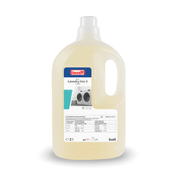 Een grote kunststof fles met Buzil Buz® Laundry Enz 3 L 820, een enzymatisch vloeibaar wasmiddelconcentraat van BUZIL-WERK Wagner GmbH & Co. KG voor professionele gebruikers, is voorzien van een handig handvat. Op het etiket staan afbeeldingen van wasmachines en belangrijke productinformatie. De vloeistof in de fles is lichtgeel van kleur.