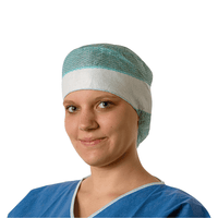 Une jeune médecin porte une blouse chirurgicale bleue et une charlotte chirurgicale jetable Hartmann Foliodress® Cap Comfort Form Plus, fabriquée en non-tissé de viscose respirant, et sourit doucement à la caméra. L'arrière-plan est d'un blanc uni.