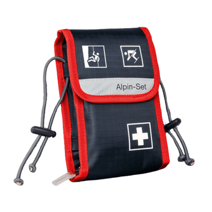 Een compacte EHBO-set in marineblauw en rood met witte symbolen die verschillende noodsituaties weergeven. De Holthaus Medical GmbH & Co. KG Alpin-Set verbandtas – 21-delig – is voorzien van het opschrift „EHBO-set“ en is aan beide zijden uitgerust met verstelbare trekkoorden.