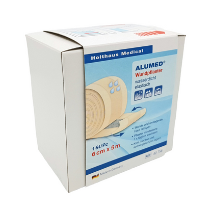 Une boîte blanche de pansements Holthaus Alumed® de 6 cm x 5 m de Holthaus Medical GmbH & Co. KG montre une image du rouleau de pansement et indique qu'il est hypoallergénique, imperméable et élastique. Le texte sur la boîte du pansement imperméable est principalement en allemand. Le produit est fabriqué en Allemagne.