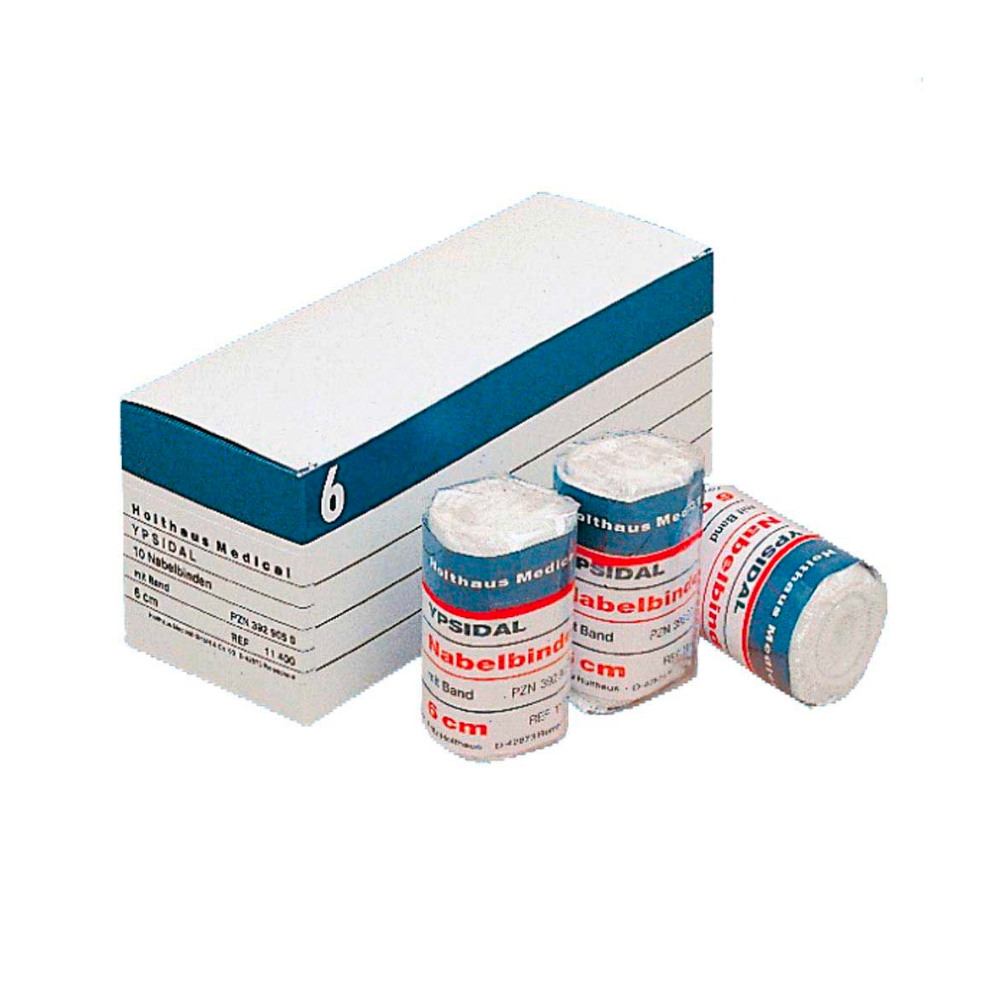 In een witte doos met het opschrift 'Holthaus YPSIDAL Navelbinde' en blauwe en witte strepen bevindt zich een rol van een 6 cm x 2 m grote medische bandage van 100% katoen. Voor de doos liggen drie rollen elastische bandage 'Mollelast Medical' met het opschrift '8 cm'.