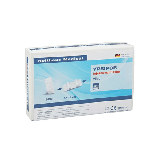 L'objet exposé est une boîte de pansements injectables Holthaus Ypsipor, fabriqués par la société Holthaus Medical GmbH & Co. KG. L'emballage, principalement blanc avec des touches de bleu, contient 100 pansements mesurant 1,5 x 4 cm. La boîte comporte un texte en allemand et une illustration des pansements.