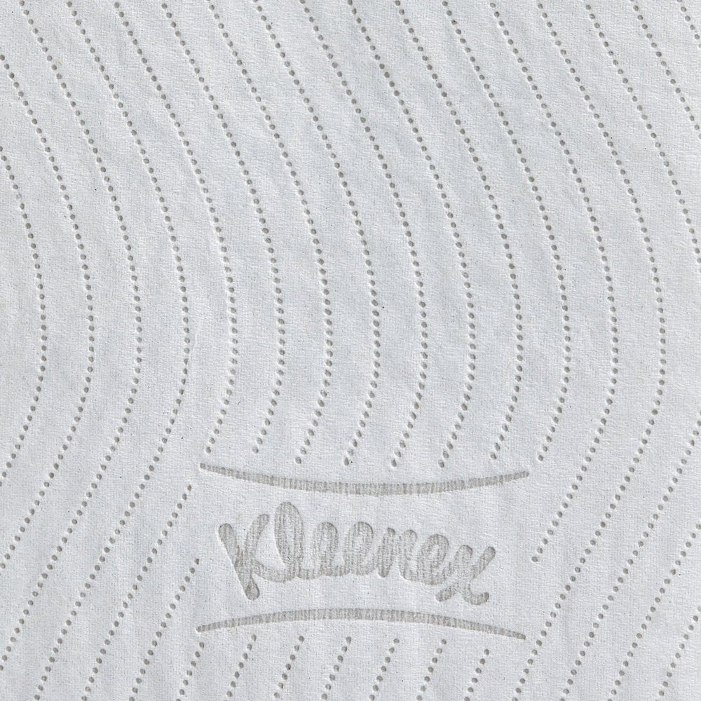 Le gros plan d'un rouleau de papier toilette blanc Kleenex® de la société Kimberly-Clark GmbH montre des lignes ondulées et pointillées et l'inscription "Kleenex" en relief gris, soulignant la texture de haute qualité de ce carton de 8 paquets (12 petits rouleaux à 250 feuilles).