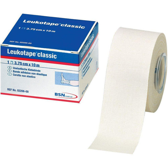 Un rouleau de bandage Leukotape Sport Tape Classic (3,75 cm x 10 m, blanc) de la marque BSN Medical GmbH, destiné aux blessures sportives, est partiellement déroulé ; le nom du produit, ses dimensions et la marque sont indiqués sur l'emballage.