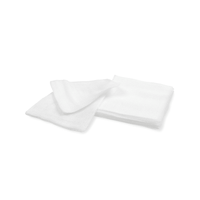 Deux compresses de gaze blanches et stériles Meditrade BeeSana®, stérilisées par simple stérilisation, pliées en 12, soigneusement pliées et empilées sur un fond blanc uni.