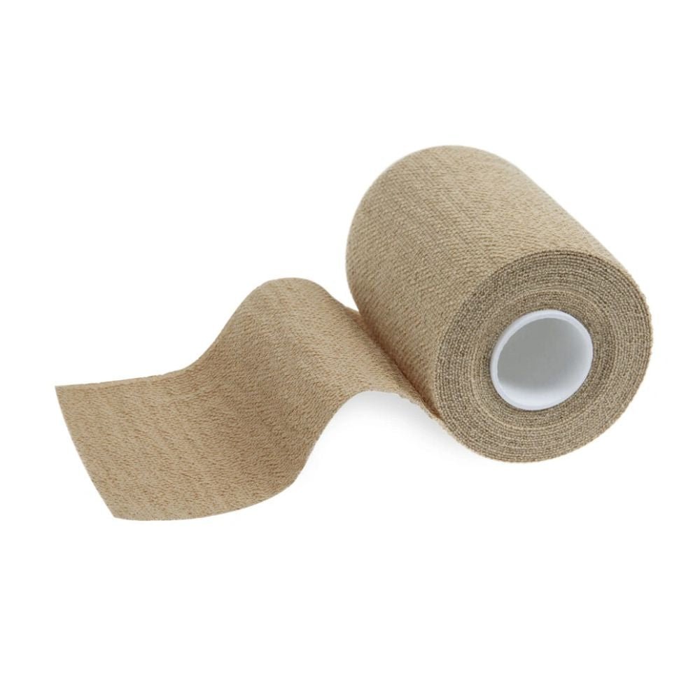Een rol beige zelfklevende tape, zoals de Meditrade ABE® extra kleefkracht cohesieve korte rekverband van Meditrade GmbH, wordt gedeeltelijk afgerold om de textuur vrij te geven. Met een zichtbare witte cilindrische kern is deze veelzijdige tape perfect geschikt voor medische of sportieve toepassingen.