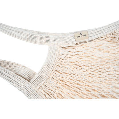 Close-up van het beige ENA Living boodschappennet van Abena Re-Seller GmbH met dikke, gevlochten handvatten en een klein "ENA LIVING"-schild. Ideaal voor milieubewuste aankopen. Verpakkingsunit: doos (24 verpakkingen), achtergrond: wit.