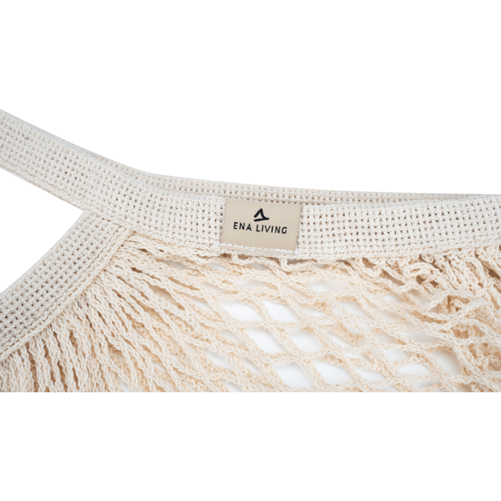 Close-up van een crèmekleurig ENA Living boodschappennet van Abena Re-Seller GmbH met stevig, gevlochten handvat en "ENA LIVING"-label - perfect voor milieubewust winkelen; verkrijgbaar als doos (24 verpakkingen).