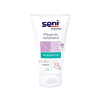 La photo montre un tube de crème nourrissante pour les mains Seni Care de la société TZMO Deutschland GmbH sur fond blanc. L'étiquette met en avant les caractéristiques « régénération » et « vegan » et souligne la formule à base de 3 % d'urée et de vitamine E pour son effet hydratant.