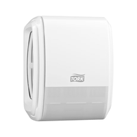 Een Tork 256010-dispenser voor continue luchtverfrissing met vernevelingstechnologie voor een verfrissende geur is aan de muur bevestigd. Het slanke ontwerp is voorzien van een halfdoorzichtige bodem waardoor de rol binnenin zichtbaar is, terwijl het Tork-logo prominent in het midden is aangebracht om uw toiletbezoek nog aangenamer te maken.
