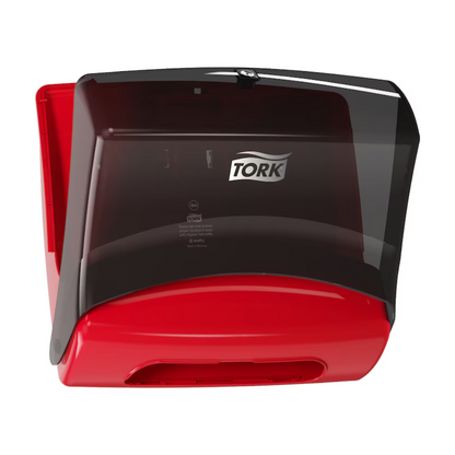 Aan de muur is een Tork 654008 enkelvoudige doekjesdispenser Performance W4 van Essity Professional Hygiene Germany GmbH in de kleuren rood en zwart gemonteerd. De transparante zwarte afdekking biedt een goed zicht op de doekjesrol binnenin en is daardoor ideaal voor professionele reiniging.