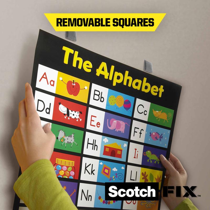 Une personne fixe un tableau de lettres sur un mur avec les carrés de montage amovibles Scotch-FIX™ 108-ST64-P (12,7 mm x 12,7 mm, 64 pièces/paquet) de 3M Deutschland GmbH pour une fixation pratique et temporaire ; "Carrés amovibles" est marqué en jaune.