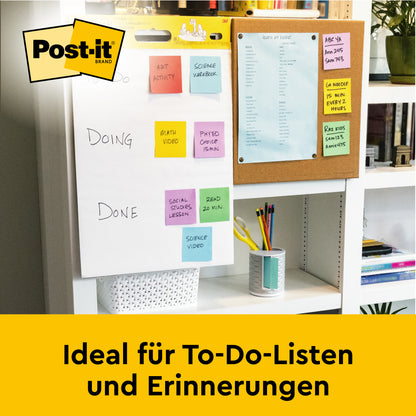 Auf dem Schreibtisch steht ein Post-it® Super Sticky selbsthaftendes Meeting Chart/Flipchart von 3M Deutschland GmbH (weiß, 63,5x76,2cm), perfekt für To-Do-Listen & Erinnerungen. Im Hintergrund: eine Pinnwand mit blauem Papier.
